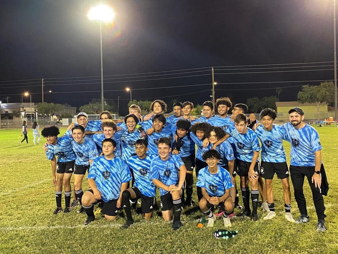 The Madison Highland Prep boys soccer team together on the field under the lights