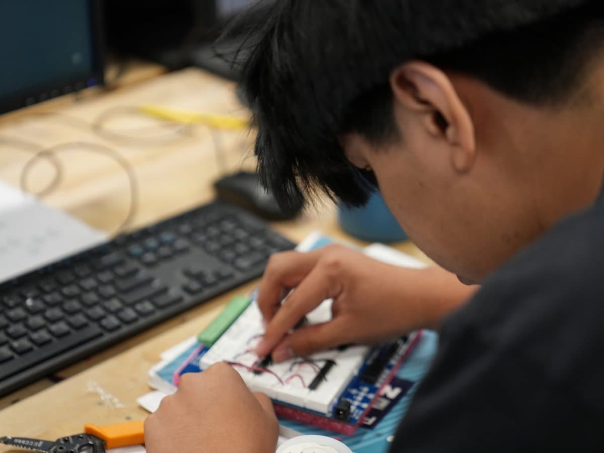 A Madison Highland Prep student wiring and soldering a custom electronics circuit