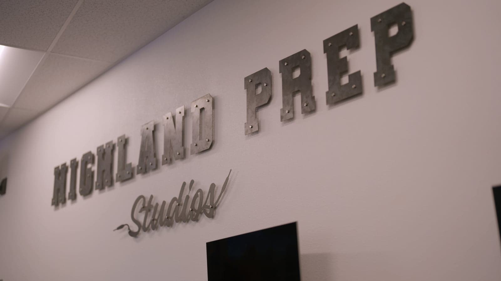 A metal Madison Highland Prep Studios sign fabricated by students, mounted on a wall